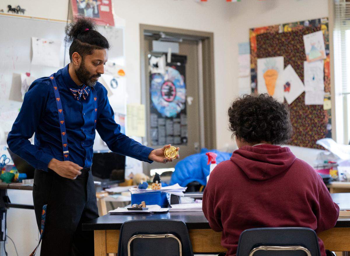 Elliot Scaife, science teacher and adviser for the BIPOC Club, demonstrates how a gyroscope works before the BIPOC Club meeting at Orting Middle School, on Wednesday, March 6, 2024, in Orting, Wash.