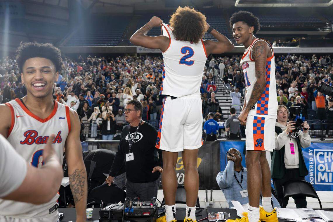 Rainier Beach guard Nyale Robinson (2) and guard Jaylen Petty (11) celebrate on top of the scorers table after the Vikings beat Edmonds-Woodway, 68-48, in the Class 3A state championship game at the Tacoma Dome on Saturday, March 8, 2025, in Tacoma, Wash.