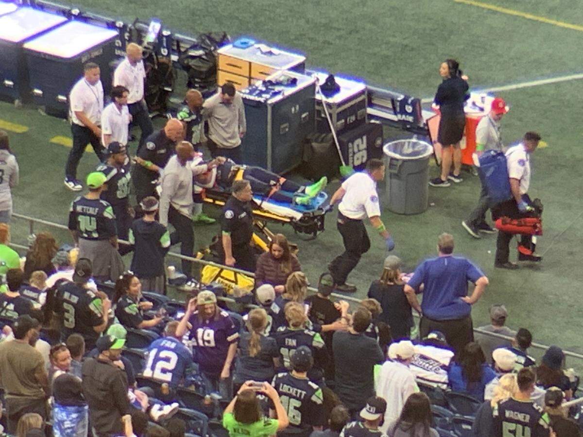 Seahawks wide receiver Cade Johnson leaves Lumen Field’s playing area with his head and neck immobilized to a stretcher during the second quarter of an NFL preseason game against the Minnesota Vikings in Seattle Aug. 10, 2023.