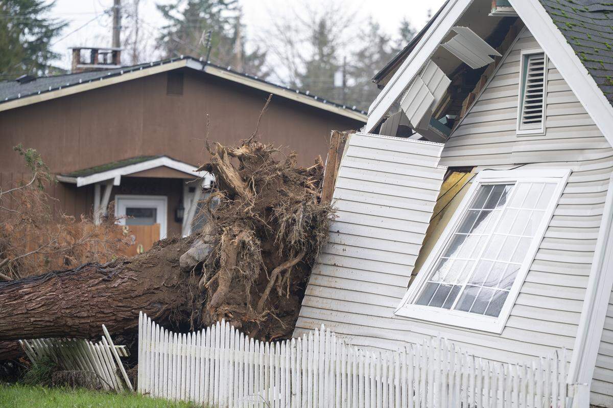 A portion of East 82nd Street is closed after a tree crashed into a home overnight on Wednesday, Dec. 17, 2025, in Tacoma, Wash.