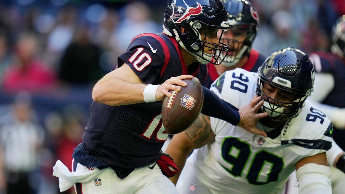 Houston Texans quarterback Davis Mills (10) is pressured by Seattle Seahawks defensive tackle Bryan Mone (90) during the first half of an NFL football game, Sunday, Dec. 12, 2021, in Houston. (AP Photo/Eric Christian Smith)