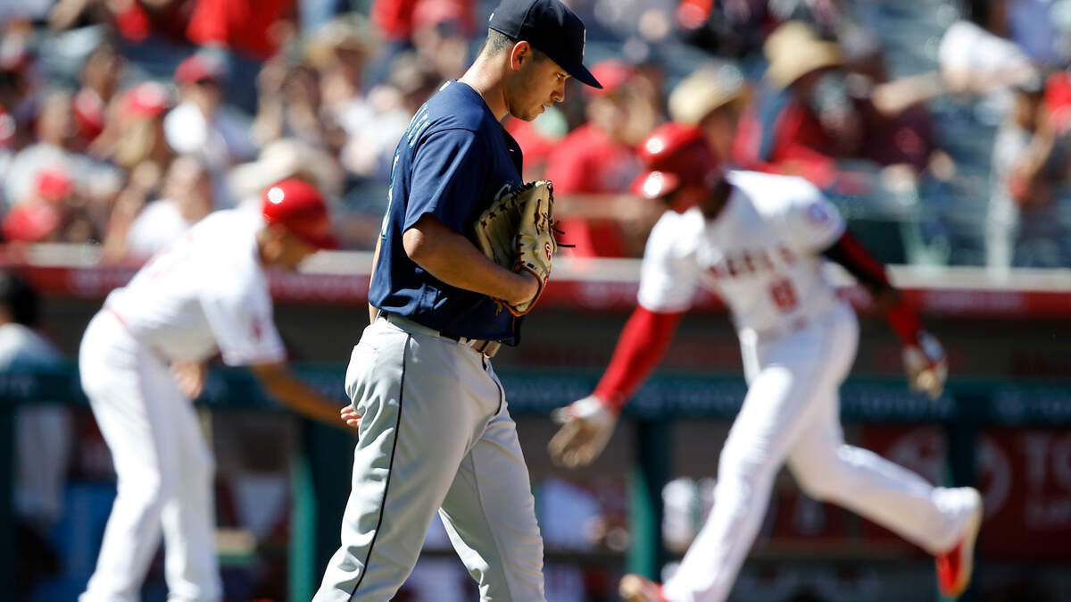 Seattle Mariners starting pitcher Marco Gonzales, foreground, walks back to the mound as Los Angeles Angels’ Justin Upton, back right, is congratulated by third base coach Dino Ebel, back left, during the third inning of a baseball game in Anaheim, Calif., Sunday, Sept. 16, 2018. (AP Photo/Alex Gallardo)