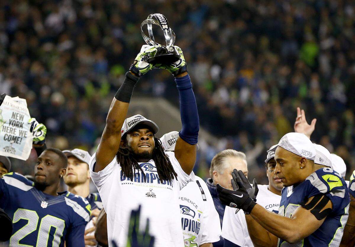 SEATTLE, WA - JANUARY 19: Cornerback Richard Sherman #25 of the Seattle Seahawks celebrates with the George Halas Trophy after the Seahawks defeat the San Francisco 49ers 23-17 in the 2014 NFC Championship at CenturyLink Field on January 19, 2014 in Seattle, Washington. (Photo by Jonathan Ferrey/Getty Images)
