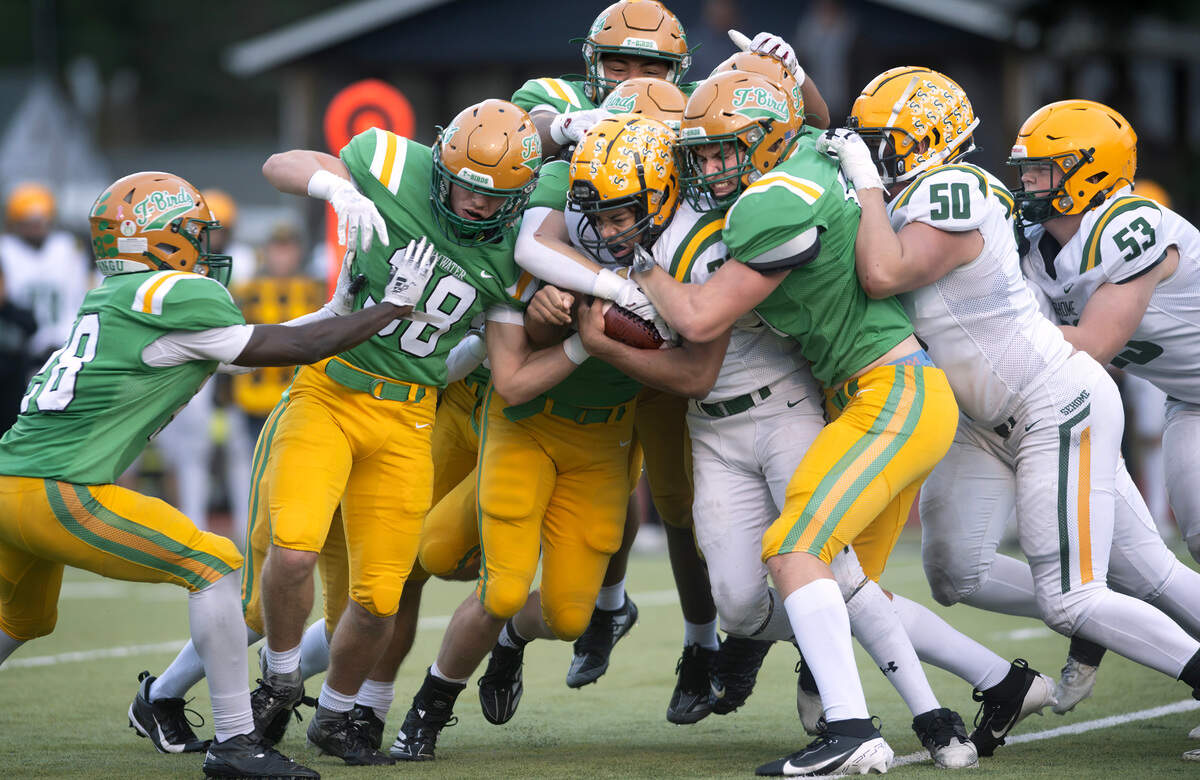 Sehome running back Solomon II Mcalister is swarmed by Tumwater defenders during Satuday afternoon’s state playoff game at Tumwater District Stadium in Tumwater, Washington, on Friday, Nov. 23, 2024. Tumwater won the game, 70-7, to advance to the state semifinals.