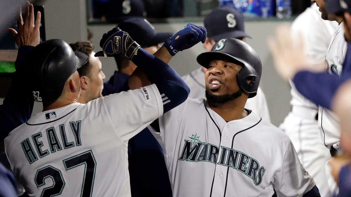 Seattle Mariners’ Edwin Encarnacion, right, smiles as he is congratulatedd in the dugout after his solo home run against the Chicago Cubs during the seventh inning of a baseball game Tuesday, April 30, 2019, in Seattle.