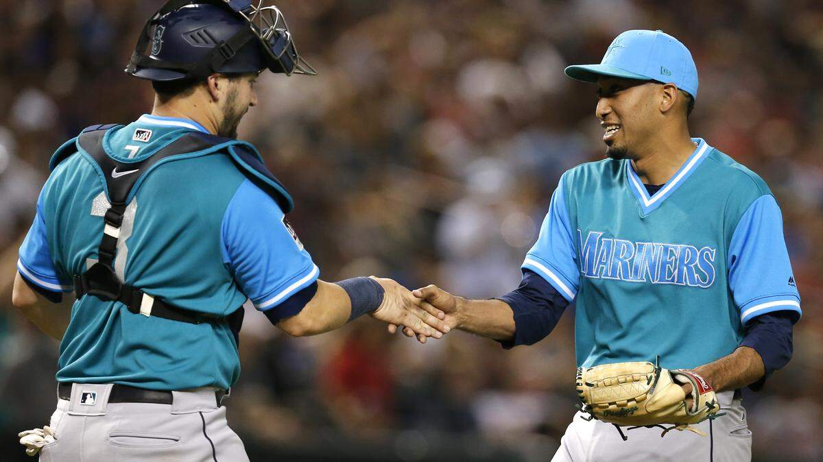 Seattle Mariners catcher Mike Zunino (3) and Edwin Diaz celebrate after the Mariners defeated the Arizona Diamondbacks 6-3 during a baseball game Friday, Aug. 24, 2018, in Phoenix. (AP Photo/Rick Scuteri)