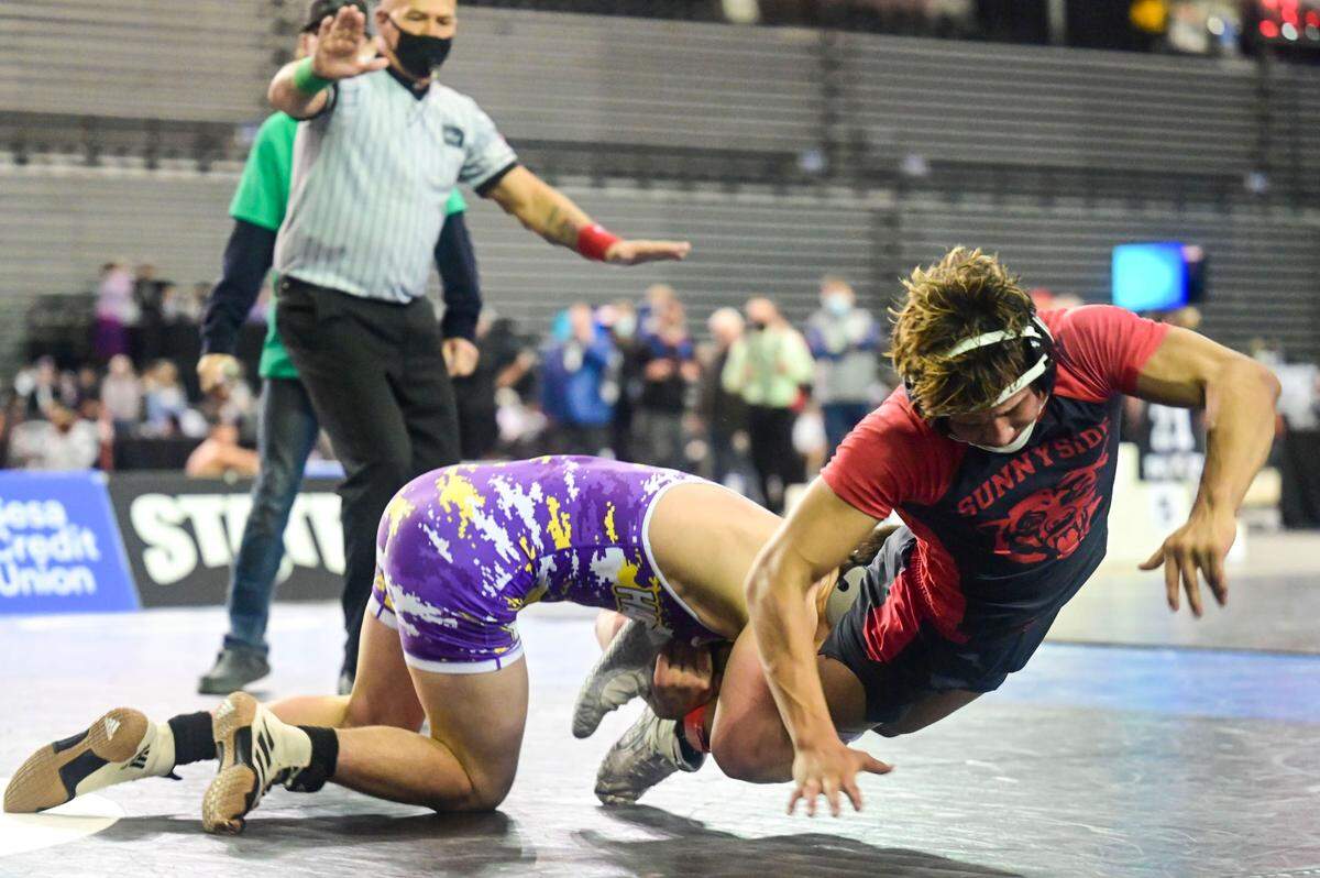 Hanford’s Jake Hubby grabs the legs of Sunnyside’s Christopher Villanueva as he tries to earn an escape point in overtime during their 138-pound 4A championship match at Mat Classic XXXIII on Saturday, Feb. 19, 2022, at the Tacoma Dome in Tacoma, Wash.