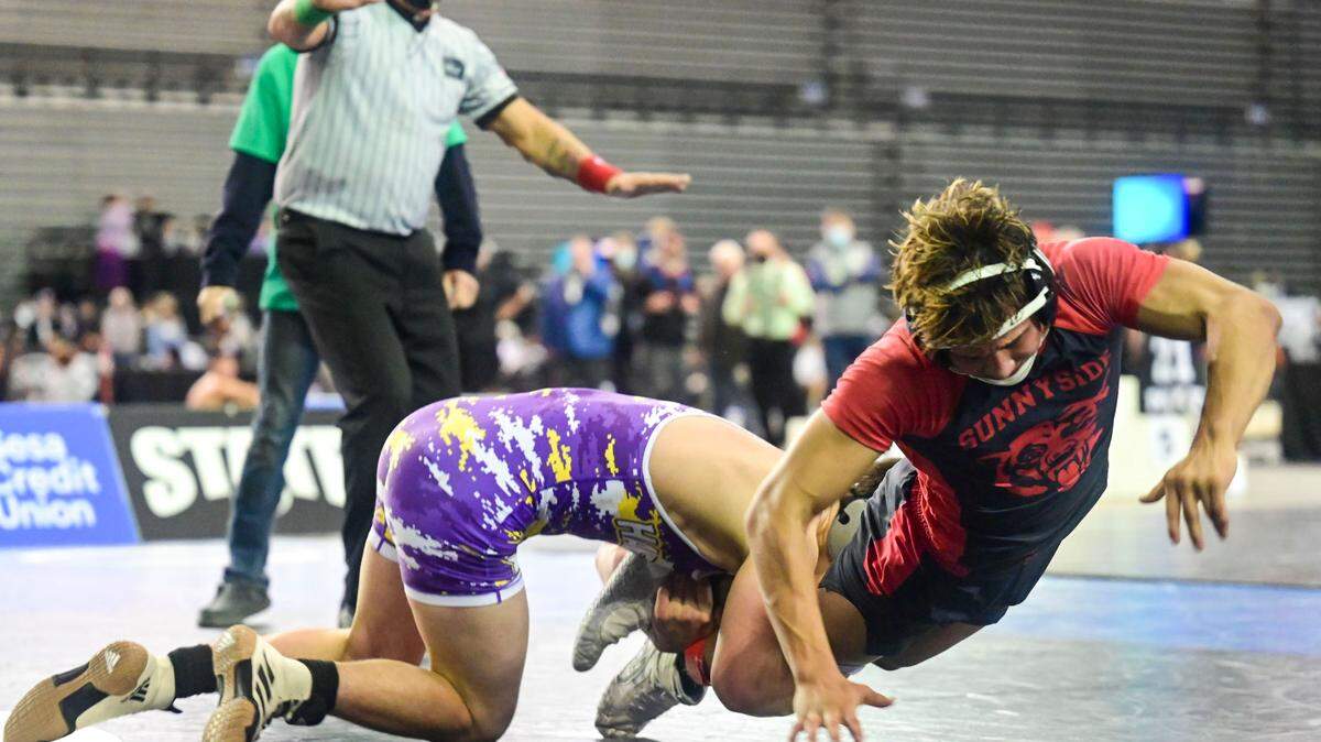 Hanford’s Jake Hubby grabs the legs of Sunnyside’s Christopher Villanueva as he tries to earn an escape point in overtime during their 138-pound 4A championship match at Mat Classic XXXIII on Saturday, Feb. 19, 2022, at the Tacoma Dome in Tacoma, Wash.