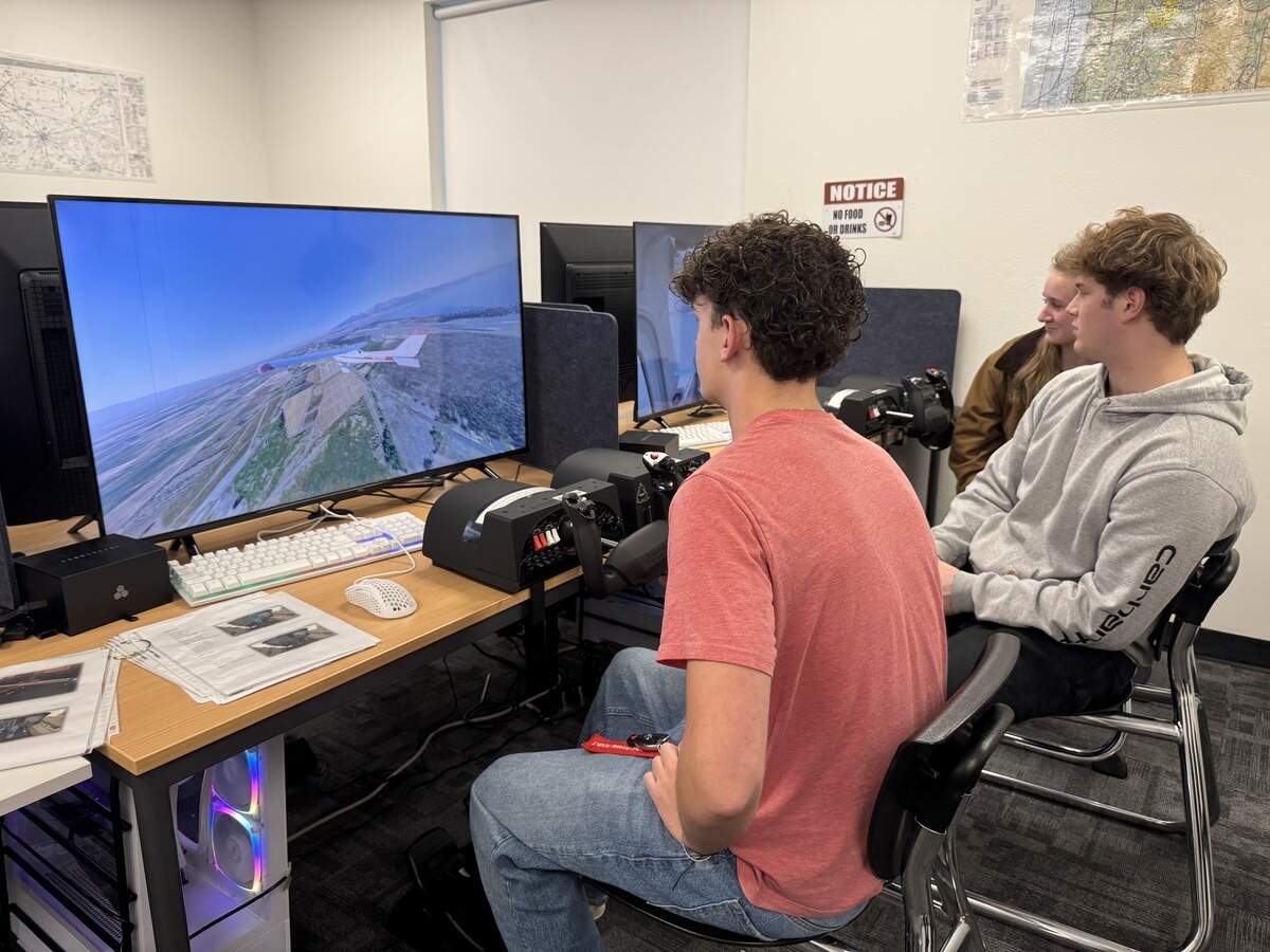 (left to right) Ben Field, Colin Donalty and Abigail Oake demonstrate how to use the flight simulators at the Peninsula School District’s Aviation Academy, Friday, Oct. 31, 2025 in Gig Harbor, Wash.