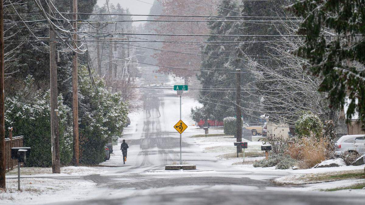A jogger makes their way through the snow on 82nd Street on Tuesday, Nov. 29, 2022, in Tacoma, Wash. Many people in the South Puget Sound woke up to snow on Tuesday. More snow is expected later in the week.