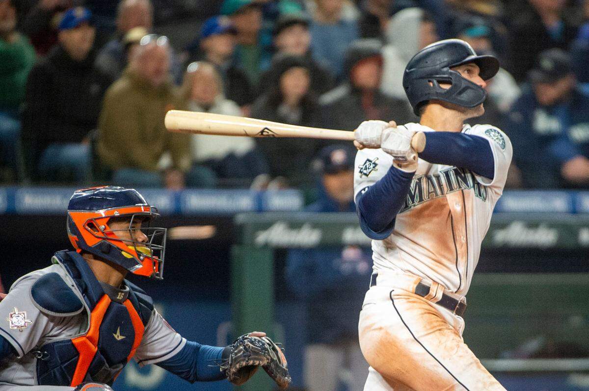 Seattle Mariners second baseman Adam Frazier (26) hits a 2-run double to right-center field in the bottom of the seventh inning of the home opener against the Houston Astros at T-Mobile Park in Seattle on Friday, April 15, 2022.