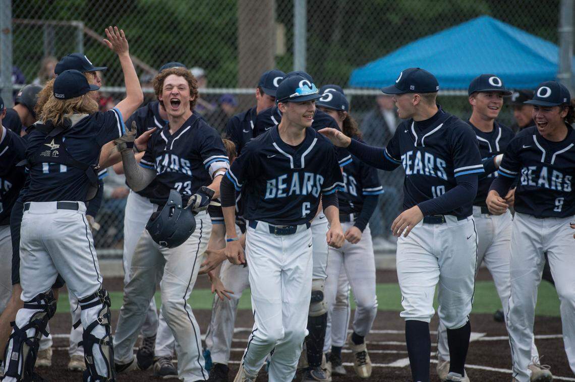Olympia High School players celebrate Logan Shepherd’s (23) two-run home run in the second inning of the Class 4A West Central/Southwest bidistrict championship game on Saturday, May 14, 2022 at Kent-Meridian High School in Kent, Wash. Olympia beat Puyallup, 8-4, to win the title.