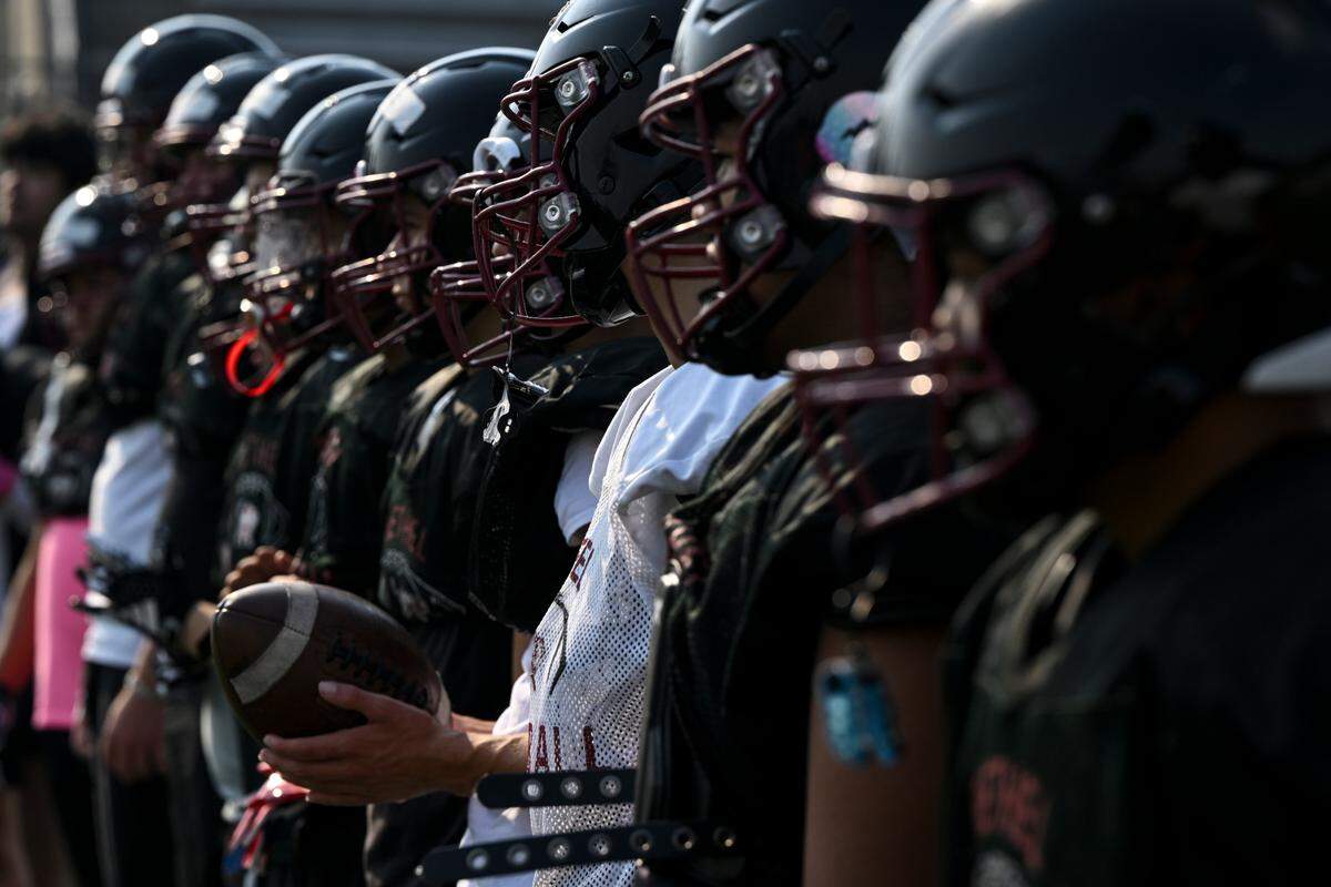 Bethel student-athletes watch as other players run drills during a practice at Bethel High School, Monday, Aug. 21, 2023, in Spanaway, Wash.