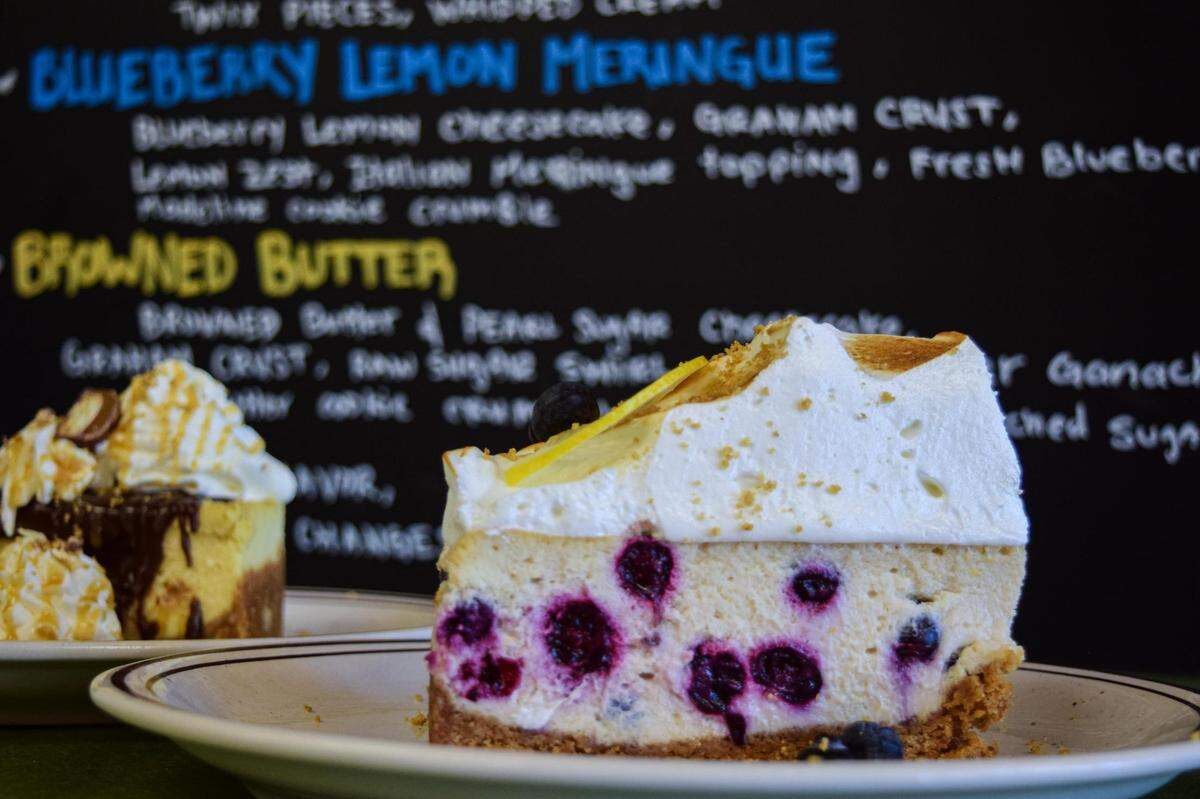 The blueberry lemon meringue cheesecake towers in front of the menu and fellow one-off slice of Twix.