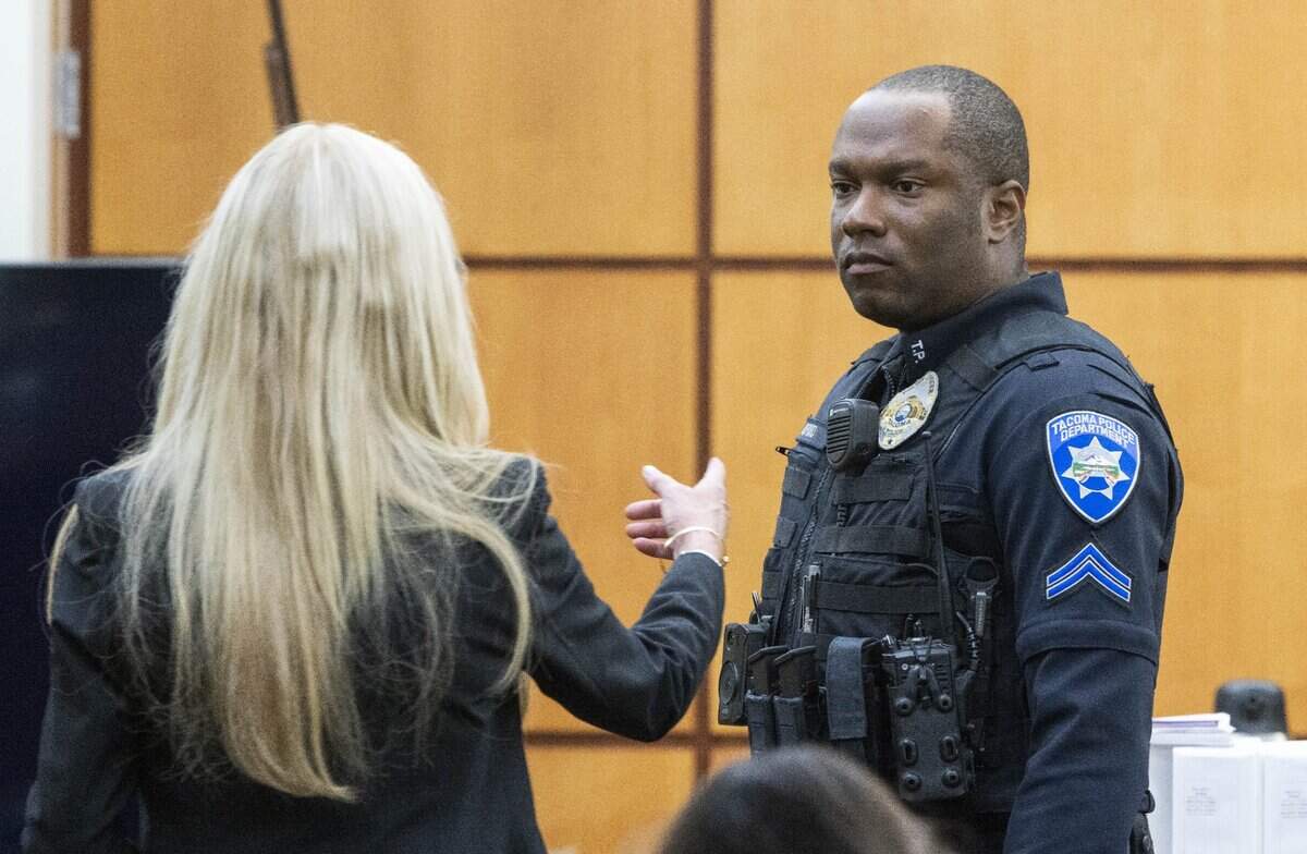 Tacoma Police Officer Masyih Ford, right, stands so he can show defense attorney Anne Bremner, attorney for Timothy Rankine, and the jury the gear he carries in Pierce County Superior Court Wednesday Nov. 15, 2023, in Tacoma, WA. Officers Christopher Burbank, Matthew Collins and Timothy Rankine are charged with the death of Manny Ellis. Ford was RankineÕs partner at the time of his killing. (Ellen M. Banner / Pool / The Seattle Times)