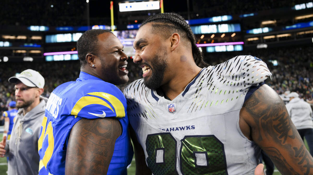 Los Angeles Rams offensive tackle D.J. Humphries (72) and Seattle Seahawks defensive end Leonard Williams (99) embrace after the Seattle Seahawks 38-37 overtime victory at Lumen Field, on Thursday, Dec. 18, 2025, in Seattle.