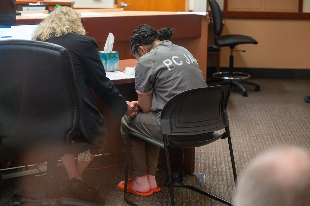 Defense attorney Laura Carnell, left, holds the hand of Ivey Lewis, 27, as Lewis cries during her plea hearing and sentencing on Thursday, July 3, 2025, at Pierce County Superior Court in Tacoma. Lewis plead guilty to charges of homicide by abuse for beating her 3-year-old son, Prince Lewis, to death.