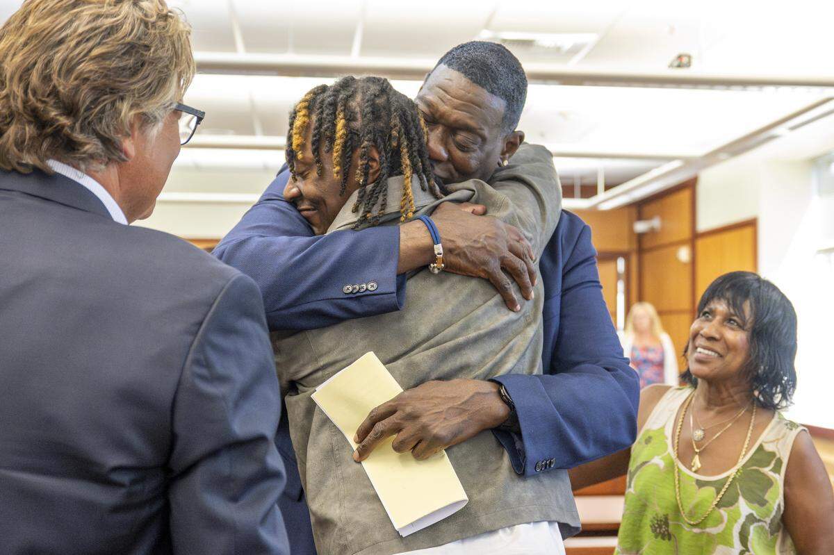 Jamon Kemp, center left, embraces father and former NBA star Shawn Kemp after a sentencing hearing for Shawn Kemp on Friday, Aug. 22, 2025, at Pierce County Superior Court in Tacoma, Wash. Kemp did not receive any jail time, and was instead ordered to 30 days of electronic home monitoring and a year of community custody, along with 240 hours of community service, to be served primarily in Tacoma and Pierce County.