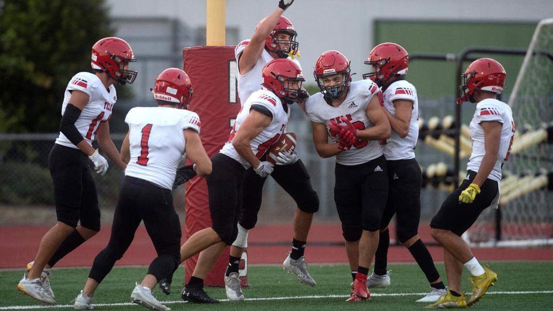 The Yelm defense celebrates Dylan Conklin’s (with ball) fumble recovery for a touchdown during Friday night’s high school football game against River Ridge at South Sound Stadium in Lacey, Washington, on Sept. 24, 2021.