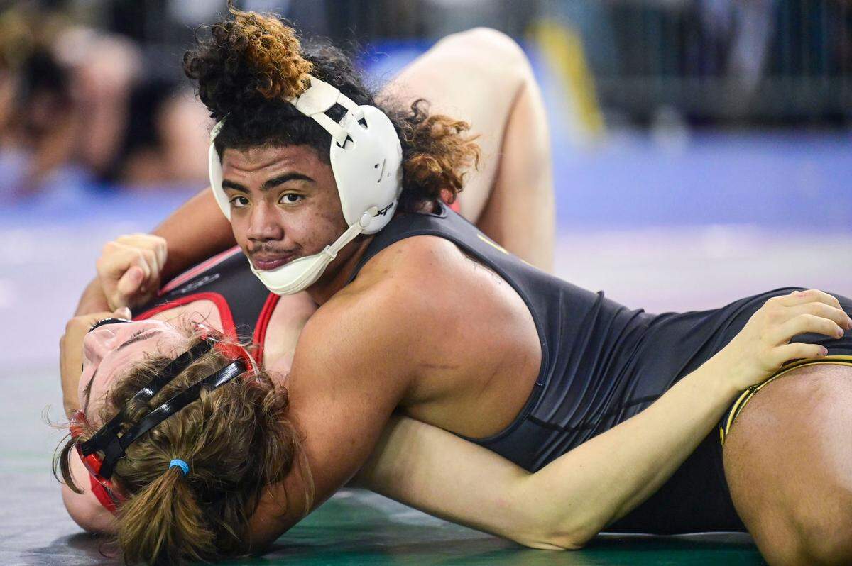 Lincoln’s Navarre Dixon waits for the shoulder blades of Cheney’s Ezra Anderson to hit the mat for a pin during the second round of their 182-pound 3A quarterfinal match at Mat Classic XXXIII on Friday, Feb. 18, 2022, in Tacoma, Wash. Dixon pinned Anderson in 3 minutes, 13 seconds.