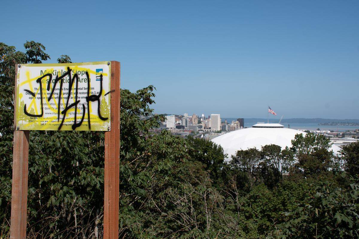 A sign detailing the on going natural restoration at McKinley Overlook is covered by graffiti on Monday, Aug. 5, 2024 in Tacoma, WA. The McKinley Overlook is set to receive a face lift which will include new landscaping. Construction on the project is set to begin this fall.