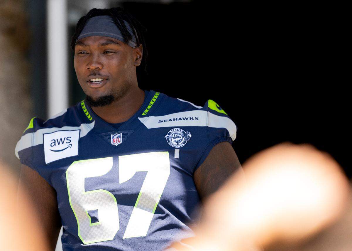 Seahawks offensive tackle Charles Cross (67) greets fans during the first day of training camp at the Virginia Mason Athletic Center, on Wednesday, July 24, 2024, at the Virigina Mason Athletic Center in Renton.