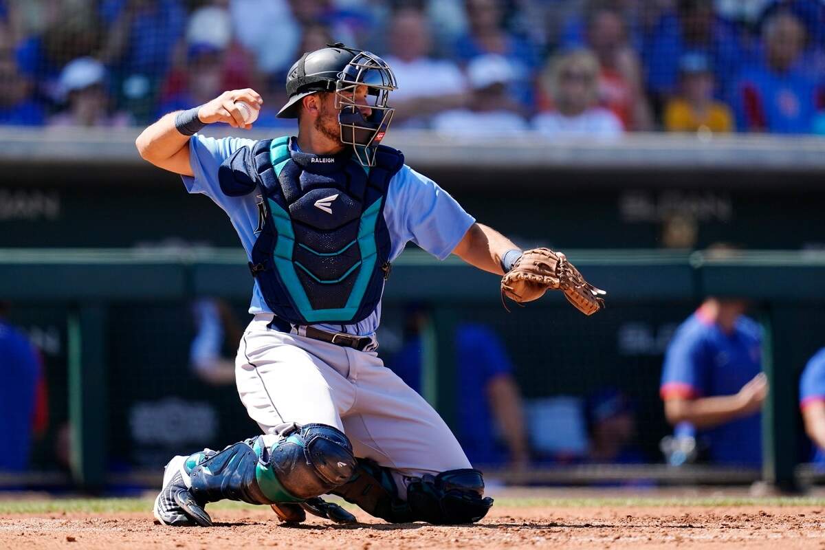 Seattle Mariners catcher Cal Raleigh throws the ball back to the pitcher during the third inning of a spring training baseball game against the Chicago Cubs Wednesday, March 30, 2022, in Mesa, Ariz. (AP Photo/Ross D. Franklin)