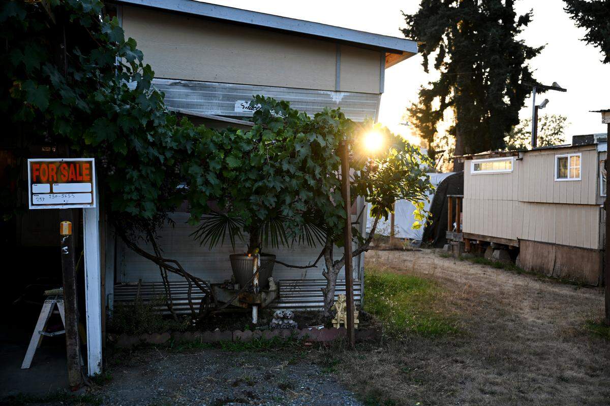 Residents display a for sale sign on their mobile home at Cottonwood Mobile Home Park, Wednesday, Sept. 13, 2023, outside Puyallup, Wash. Shortly after Hurst & Son LLC purchased the mobile home park residents started receiving door hangers notifying them of a near 50% rent hike and new fees. The price hike has forced some to leave.