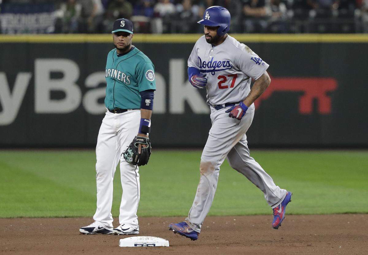 Seattle Mariners second baseman Robinson Cano, left, watches as Los Angeles Dodgers’ Matt Kemp rounds the bases with a two-run home run during the seventh inning of a baseball game Friday, Aug. 17, 2018, in Seattle. (AP Photo/Ted S. Warren)