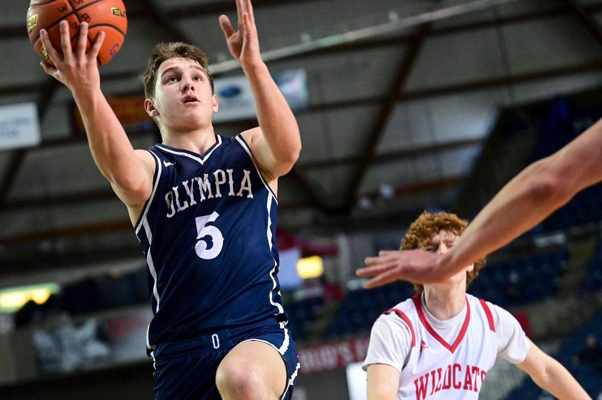 Olympia guard Mason Juergens (5) attempts a layup after dribbling past Mount Si guard Blake Forrest (2) during the first quarter of a Class 4A semifinal state tournament game on Friday, March 4, 2022, at the Tacoma Dome, in Tacoma, Wash.