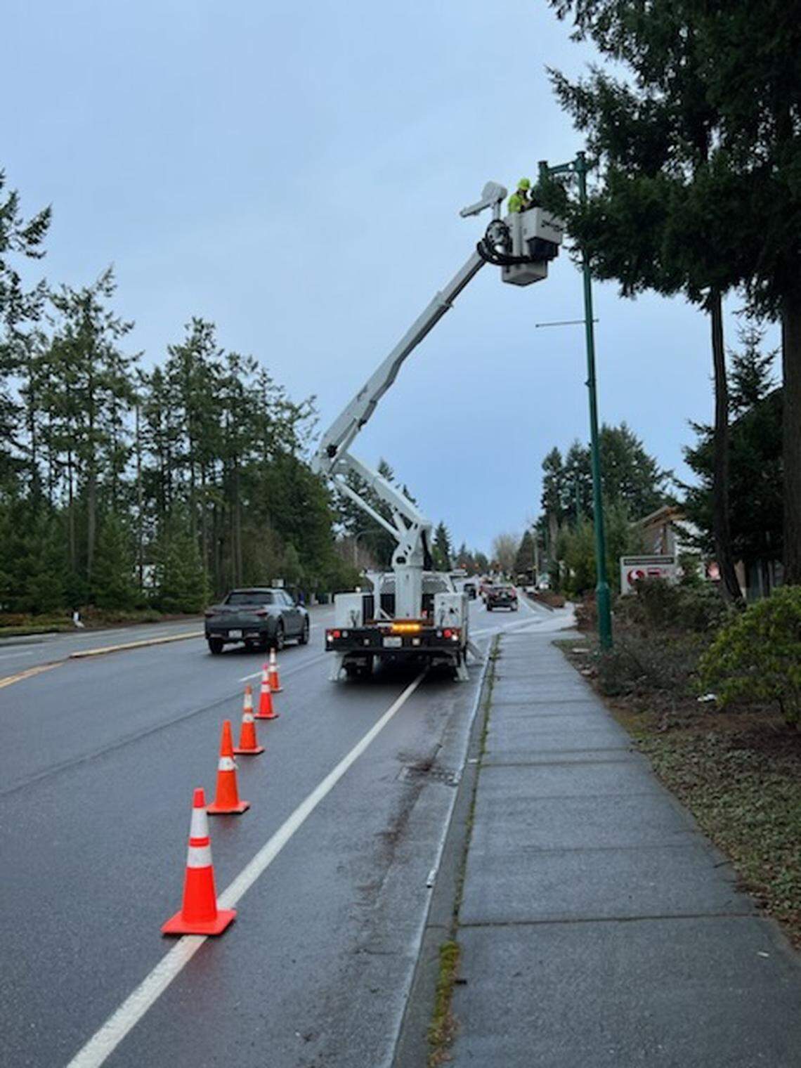 A member of the city of Gig Harbor’s operations staff removes an LED lamp from a city streetlight Jan. 25, 2024.
