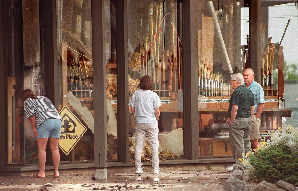 Passersby and customers peer into the front windows of Pizza & Pipes after it burned in August 1999.
