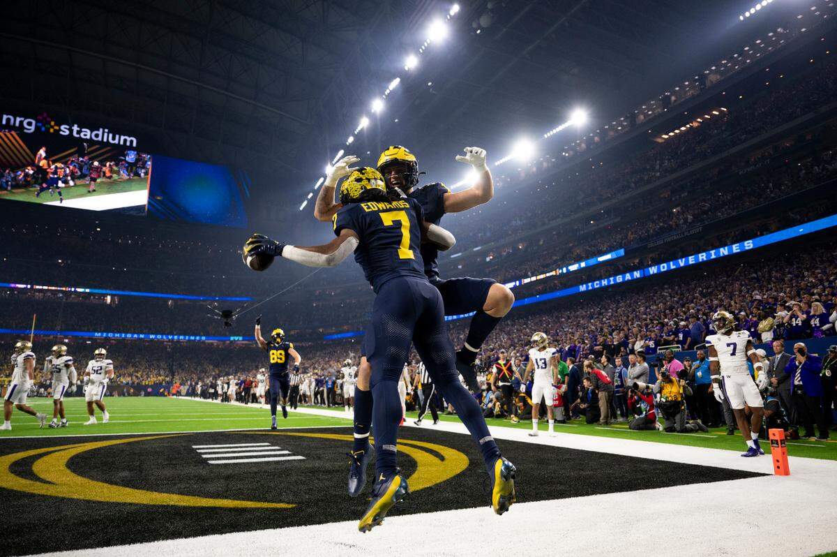 Michigan Wolverines running back Donovan Edwards (7) celebrates a touchdown with tight end Colston Loveland (18) during the first quarter of the College Football Playoff National Championship game against the Washington Huskies at NRG Stadium on Monday, Jan. 8, 2024, in Houston.