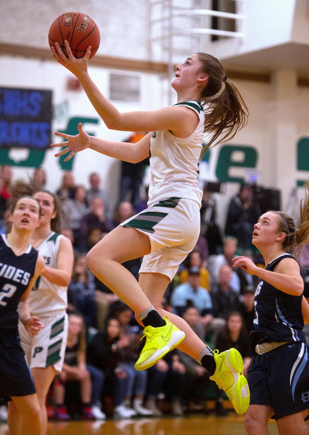 Peninsula junior guard Linsey Lovrovich flies down the lane during Wednesday night’s opening game of the crosstown rivalry basketball double header against the Gig Harbor Tides at Peninsula High School in Gig Harbor on Jan. 14, 2020.