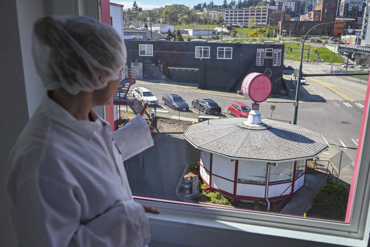 Marketing director Kathi Rennaker points to the hexagonal hut outside the Brown & Haley Almond Roca factory, on Tuesday, April 7, 2026, in Tacoma, Wash. It operates as a factory seconds store, but was originally built for the World Fair in Seattle.