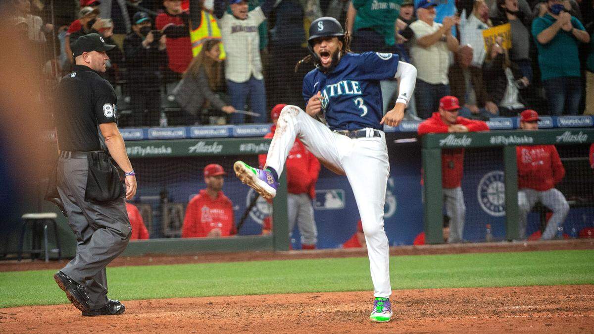 Mariners shortstop J.P. Crawford leaps with joy after scoring the go-ahead run on Mitch Haniger’s two-run single in the eighth inning that gave Seattle a 5-4 lead. The Mariners went on to win 6-4 to stay in the wild-card hunt Saturday night, Oct. 2, 2021 at T-Mobile Park in Seattle.