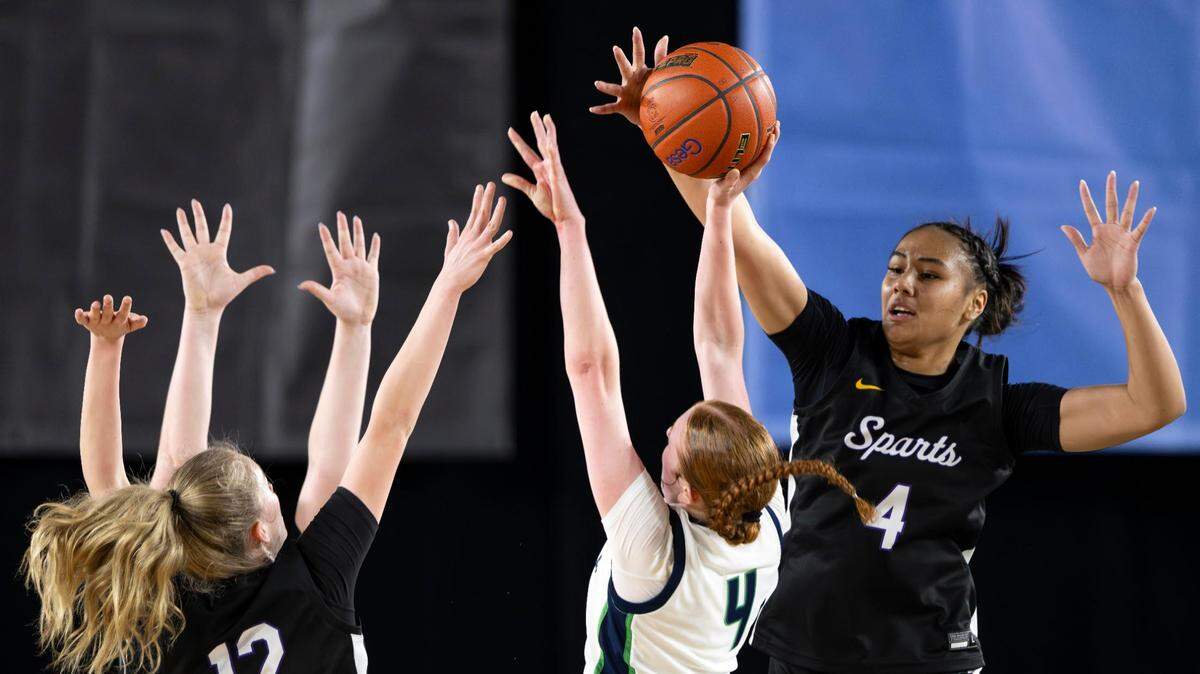 Sumner guard Kawehi Borden (4) blocks the shot of Woodinville forward Hailey Quiggle (4) during the third quarter of a Class 4A state basketball tournament semifinal game at the Tacoma Dome on Friday, March 7, 2025, in Tacoma, Wash.