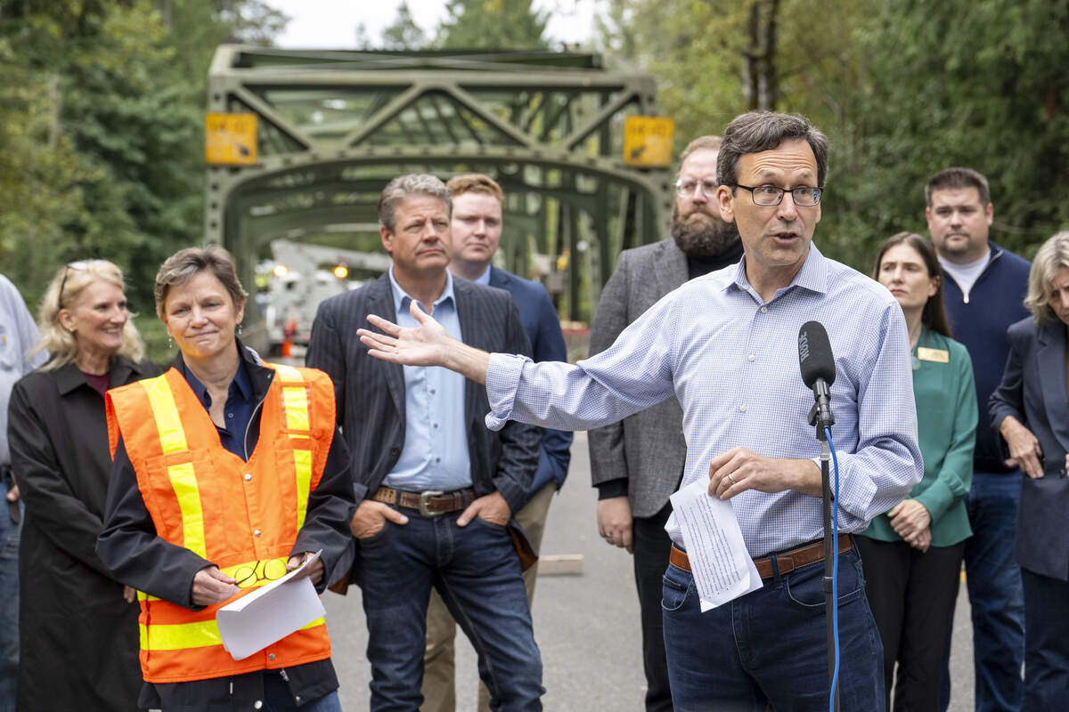 Gov. Bob Ferguson, front, speaks during a visit to the White River Bridge on Monday, Sept. 8, 2025, in Enumclaw, Wash.