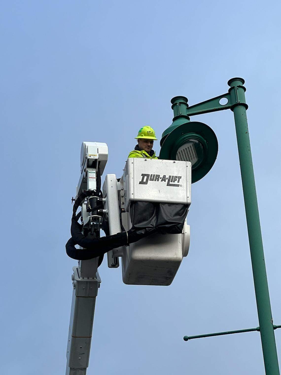 A member of the city of Gig Harbor’s operations staff removes an LED lamp from a city streetlight Jan. 25, 2024.
