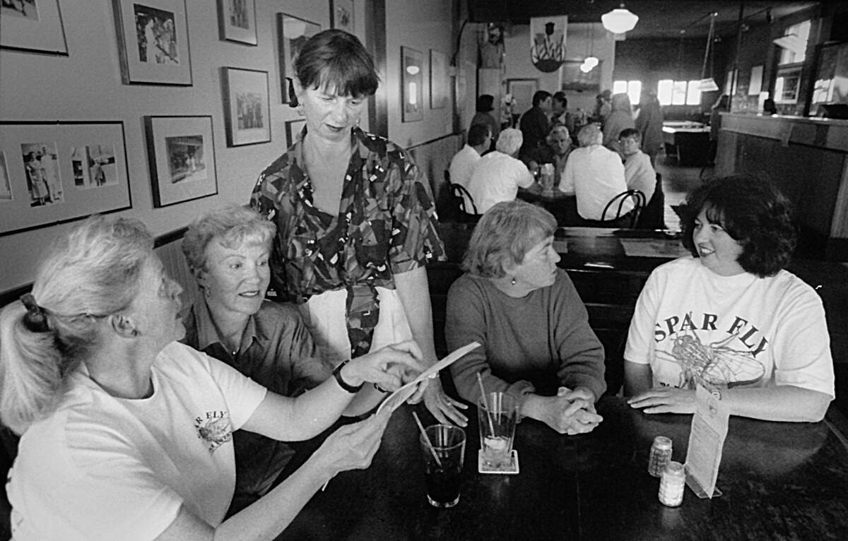 Manke, second from right, discusses an upcoming sea-to-ski, 50-mile relay race with her teammates, including Simchuk, second from left, at The Spar in 1994.
