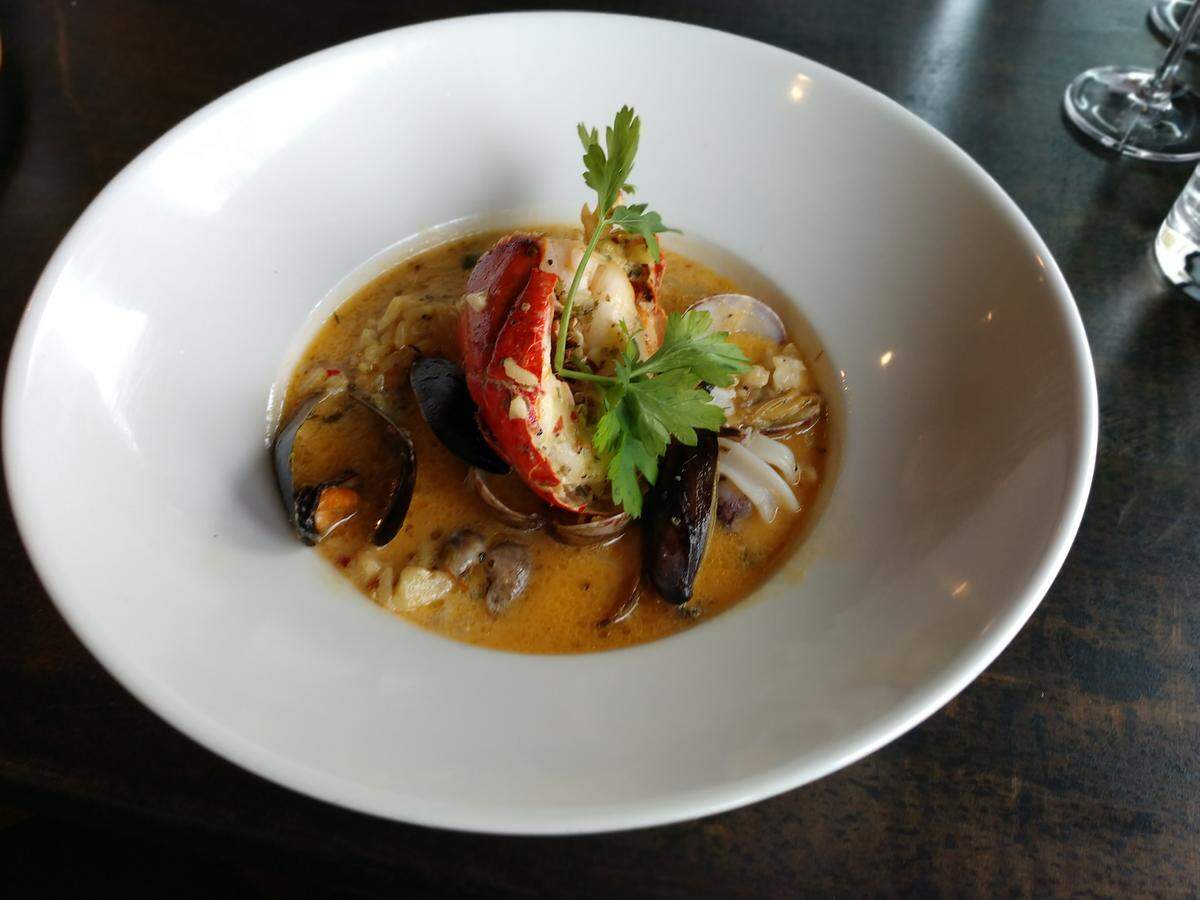Arroz ala Valenciana, with lobster, prawns, scallops and other seafood, served over Jasmine rice in a creamy fennel sauce from Gino’s at the Point on the Dash Point waterfront.
