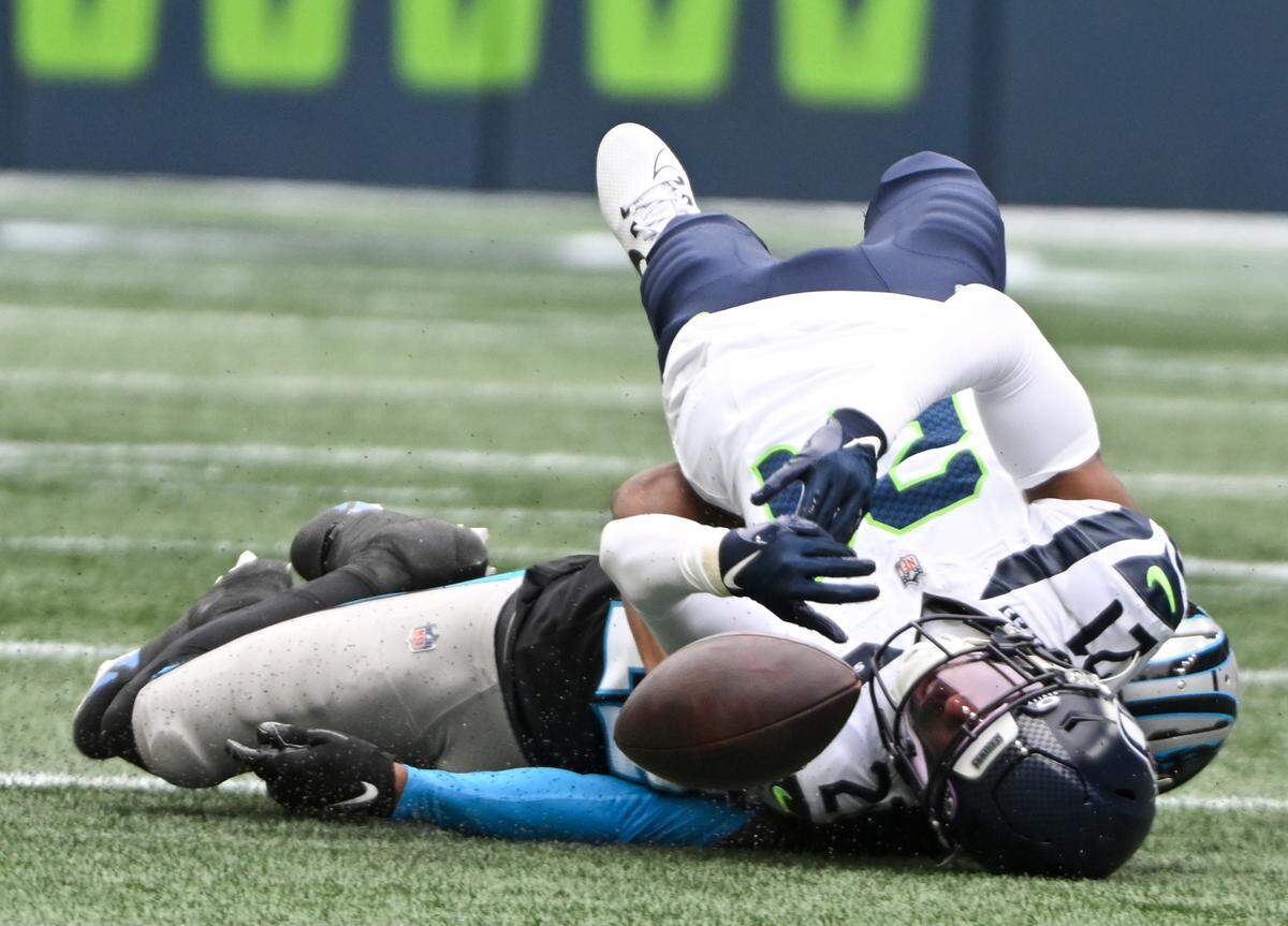 Seattle Seahawks cornerback Devon Witherspoon (21) falls on top of Carolina Panthers wide receiver DJ Chark Jr. (17) during the first quarter of the game at Lumen Field, Sunday, Sept. 24, 2023, Seattle, Wash.