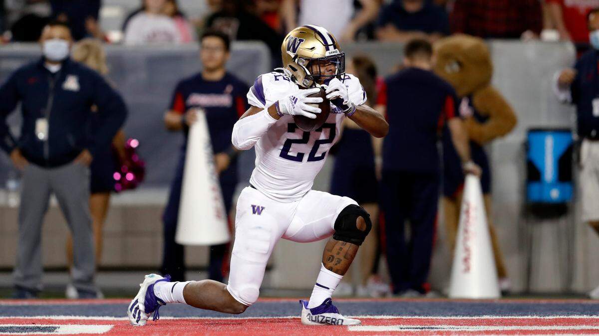 Washington running back Cameron Davis (22) reacts after scoring a touchdown during the second half of the team’s NCAA college football game against Arizona on Friday, Oct. 22, 2021, in Tucson, Ariz. (AP Photo/Chris Coduto)