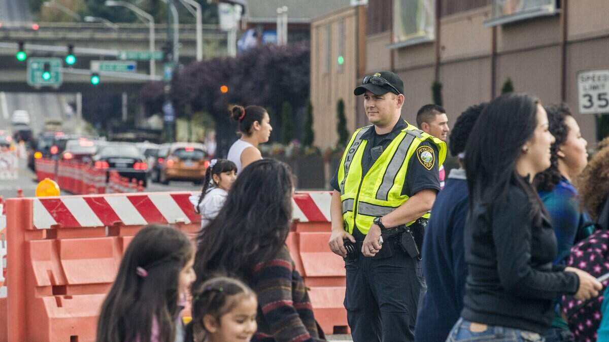 Puyallup police officer Seth Habeck controls car and pedestrian traffic outside the gold gate in an intersection on Meridian Ave. at the Washington State Fair in Puyallup.