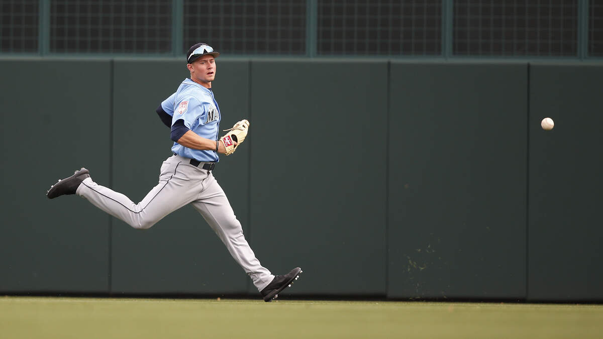 Seattle Mariners’s Jarred Kelenic chases a ball hit by hit by Los Angeles Dodgers’ Keibert Ruiz in the eighth inning of a spring training baseball game Saturday, March 9, 2019, in Phoenix.
