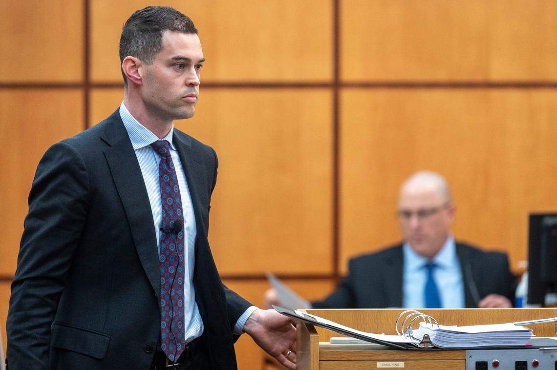 After handing Tacoma Police Department Det. Chad Lawless a piece of evidence, Nick Gross, a defense attorney for Pierce County Sheriff Ed Troyer, walks back to the podium to continue his cross examination of Lawless on Wednesday, Dec. 7, 2022, in Pierce County District Court in Tacoma, Wash.