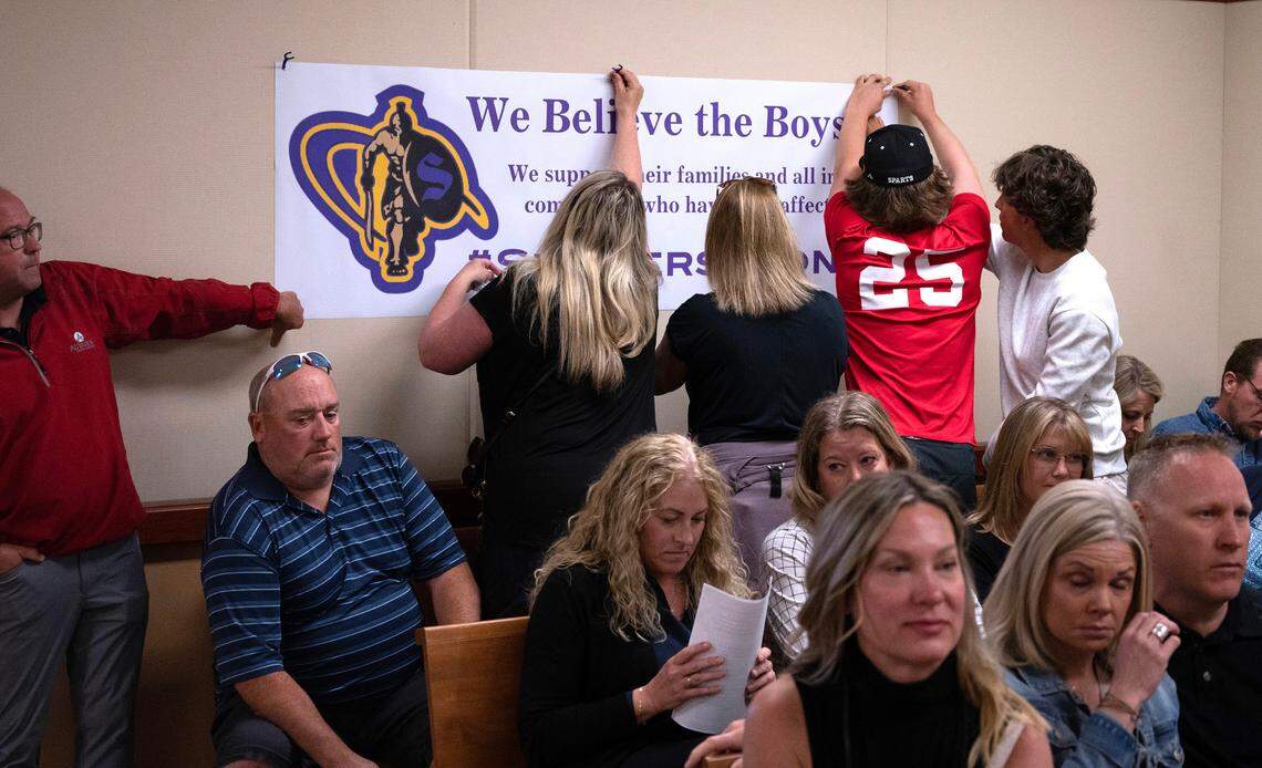 Sumner High students and parents put up a banner before the arraignment of former varsity basketball coach Jacob “Jake” Jackson on charges of third-degree child rape, indecent exposure, first-degree sexual misconduct with a minor, two counts of third-degree child molestation and five counts of communication with a minor for immoral purposes. Commissioner Craig Adams ordered Jackson be taken directly into custody following the arraignment, drawing applause from the gallery.