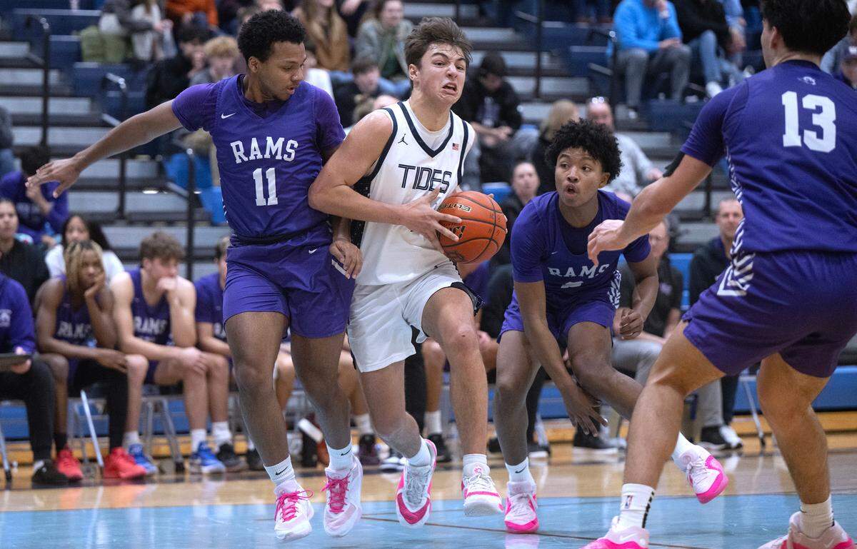 Gig Harbor’s Cole Browne drives the lane between North Thurston defenders Ahamari Steplight (11), Micah Gentry and Conner Seward (13) during Friday night’s 3A SSC boys basketball game at Gig Harbor High School in Gig Harbor, Washington, Jan. 5, 2024. After a fourth-quater rally by Gig Harbor tied the game at 45-45 in the final three minutes, North Thurston pulled away to win the game, 56-45.