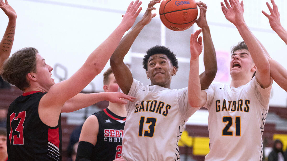 Annie Wright’s TJ Marshall (13) and Martin Kaupanger battle for a rebound against Seattle Christian’s Brett Richard during the 1A West Central District boys basketball championship game at Mount Tahoma High School in Tacoma, Washington, on Wednesday, Feb. 15, 2023. Annie Wright battled from behind, then held off multiple Warrior runs to win, 65-60.