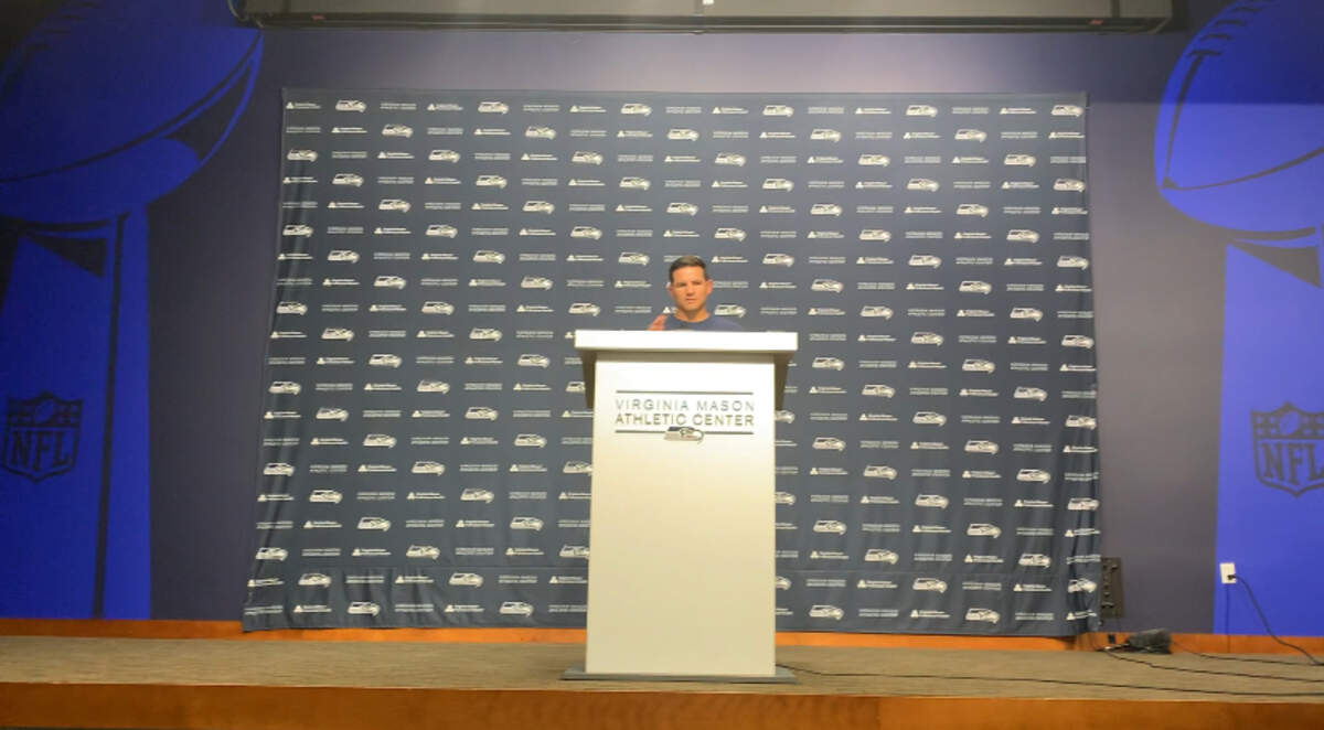 Coach Mike Macdonald conducts his first in-season press conference Sept. 4, 2024. He’s flanked by new wall murals he had put inside the Seahawks’ main auditorium at the Virginia Mason Athletic Center of the Vince Lombardi Trophy the NFL gives to its Super Bowl champion.